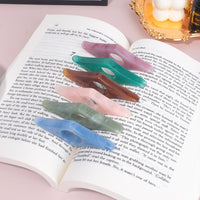 Bague de lecture en résine colorée posée sur un livre ouvert