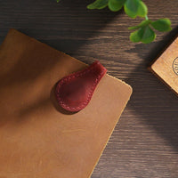 Marque-pages aimantés en cuir véritable cousu main de différentes couleurs disposés sur une table en bois