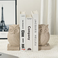 Serre-livre en résine représentant un hibou stylisé, placé de part et d’autre de plusieurs livres.