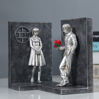 Serre-livres décoratif en résine représentant un couple séparé avec une rose rouge