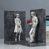 Serre-livres décoratif en résine représentant un couple séparé avec une rose rouge
